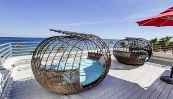 Gay-friendly hotel rooftop with unique lounge chairs offering ocean views. Perfect for snoozing in style. A luxurious, relaxing vacation spot.