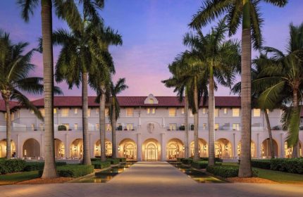 Casa Marina Key West, a Curio Collection by Hilton, gay-friendly hotel. Exterior view with palm trees at dusk. Gay travel advice.
