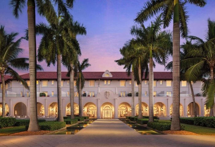 Casa Marina Key West, a Curio Collection by Hilton, gay-friendly hotel. Exterior view with palm trees at dusk. Gay travel advice.