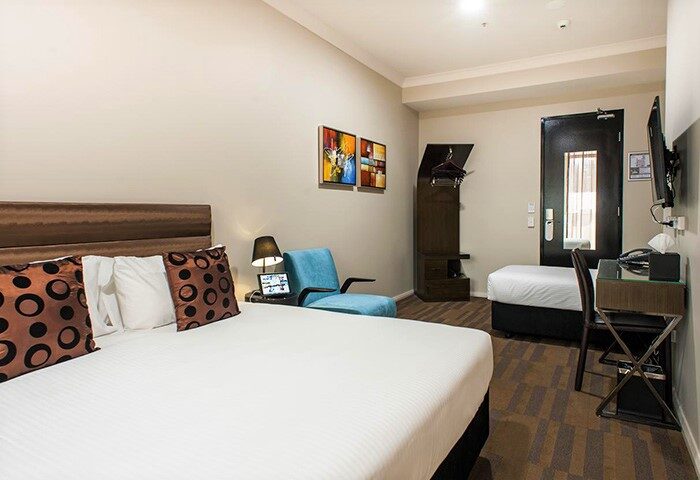 Hotel 57, a gay-friendly hotel. Interior of a room with bed, chair, desk, and closet. Modern design and comfortable amenities for gay travelers.