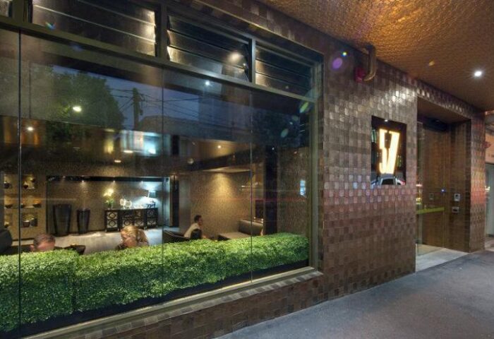 Facade of Gay-Friendly Hotel 57 Hotel. View through the window with people inside. Modern design, welcoming atmosphere.