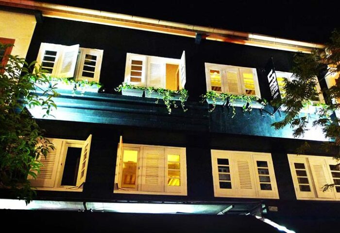 5footway.inn Project Chinatown: Gay-friendly hotel facade at night. Windows with white shutters, plants. A great choice for gay travelers.