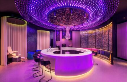 W Dubai - The Palm gay-friendly hotel bar. Chic interior with purple lighting, round bar, and stylish seating. Ideal for gay travel advice.