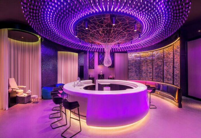 W Dubai - The Palm gay-friendly hotel bar. Chic interior with purple lighting, round bar, and stylish seating. Ideal for gay travel advice.