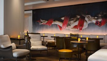 The Modern Honolulu, a gay-friendly hotel. Lounge area with art, seating, and tables. Perfect for gay men's travel advice.