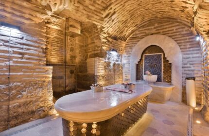 Hagia Sofia Mansions Istanbul gay-friendly hotel spa. Stone walls, vaulted ceiling, marble table. Curio Collection by Hilton. Gay travel advice.
