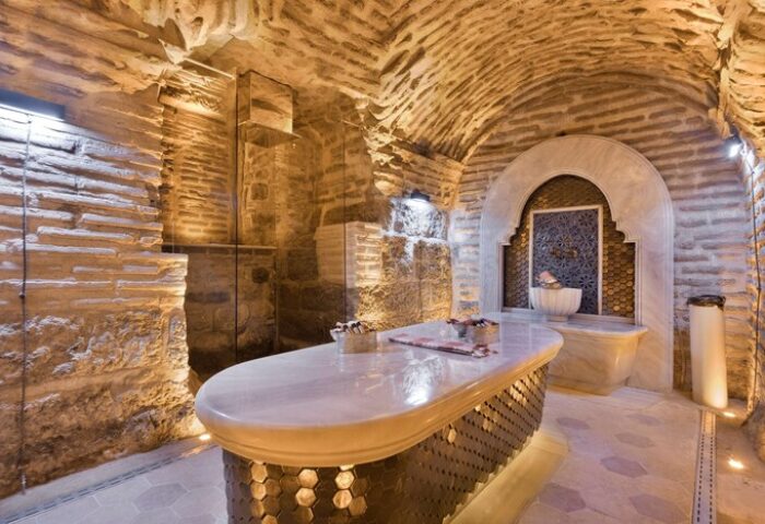 Hagia Sofia Mansions Istanbul gay-friendly hotel spa. Stone walls, vaulted ceiling, marble table. Curio Collection by Hilton. Gay travel advice.