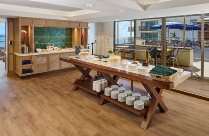 Buffet at OUTRIGGER Reef Waikiki Beach Resort, a gay-friendly hotel. Food, plates, and ocean view. Waikiki travel for gay men.