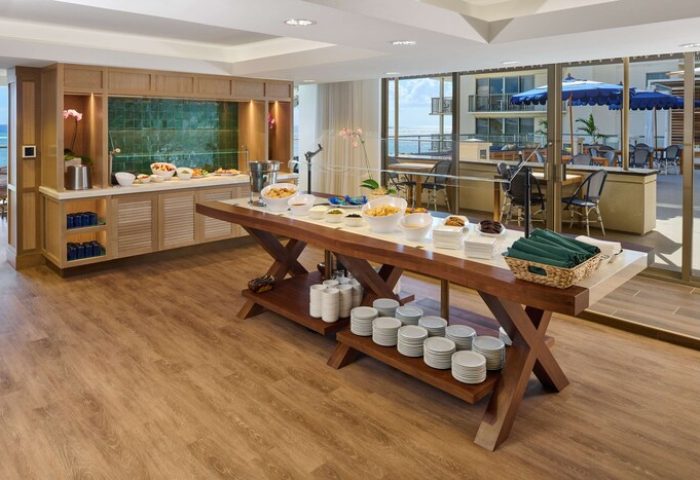 Buffet at OUTRIGGER Reef Waikiki Beach Resort, a gay-friendly hotel. Food, plates, and ocean view. Waikiki travel for gay men.