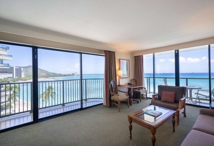 Outrigger Waikiki Beach Resort gay-friendly hotel suite. Ocean view from balcony, desk, and seating area. Perfect for gay men's travel to Hawaii.