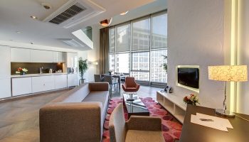 Elysium Taksim Hotel gay-friendly suite: open-plan living area with kitchen, dining, and lounge. Modern design, city view. Ideal for gay travelers.