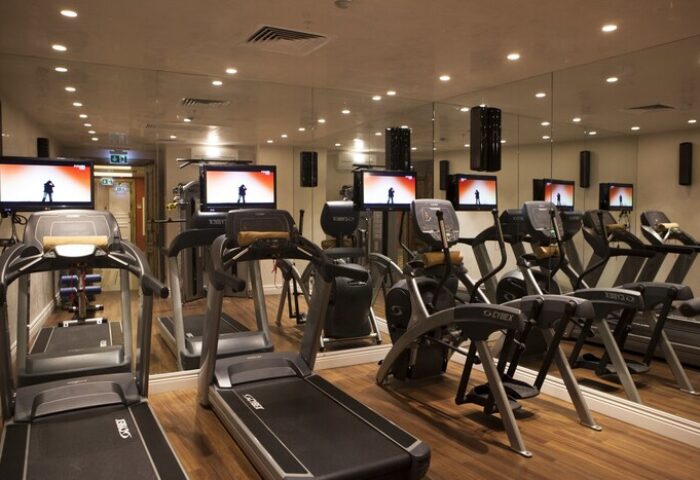 Gym at The Bank Hotel Istanbul, a Design Hotel. Treadmills and elliptical machines with TVs. Gay-friendly hotel fitness center.