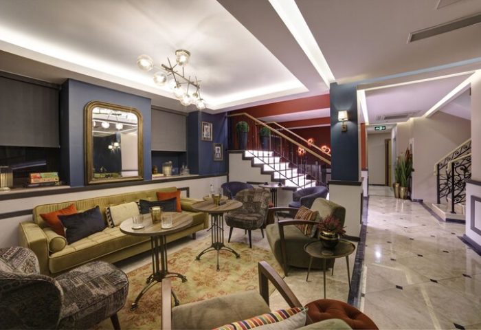 The Fox Hotel's stylish lobby. Gay-friendly hotel with seating, stairs, and a mirror. A comfortable space for gay men to relax and socialize.