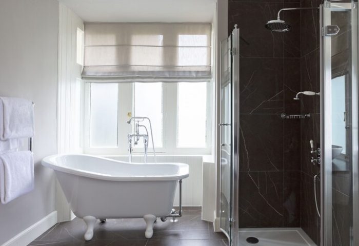 Bathroom at SCHLOSS Roxburghe Hotel, a gay-friendly hotel. Features a clawfoot tub, window, and shower. Gay travel advice for discerning men.