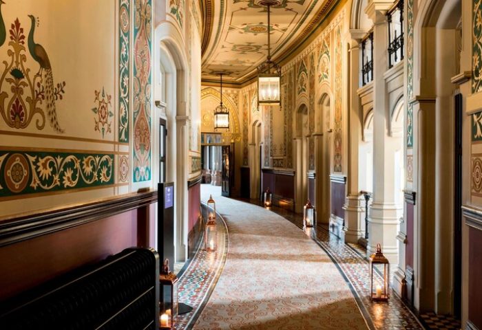 Ornate hallway at St. Pancras Renaissance Hotel, London. Gay-friendly hotel with peacock motifs, lanterns, and arched doorways. Historic luxury.