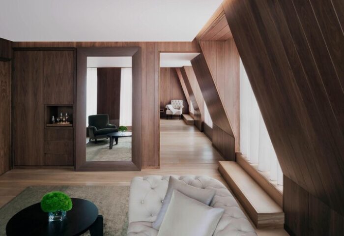Interior of The London EDITION, a gay-friendly hotel. Wood paneled walls, modern furniture, and a stylish, luxurious design.
