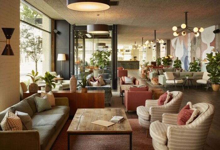 The Hoxton, Holborn: Stylish lounge area in a gay-friendly hotel. Modern design, comfortable seating, and plants create a welcoming atmosphere.