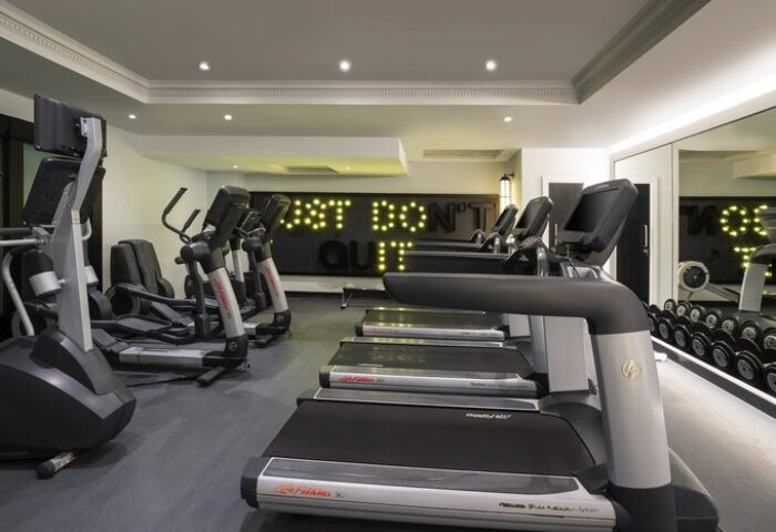 NYX Hotel London Holborn gym. Treadmills, elliptical machines, & weights. Just Don't Quit sign. Gay-friendly hotel fitness center.