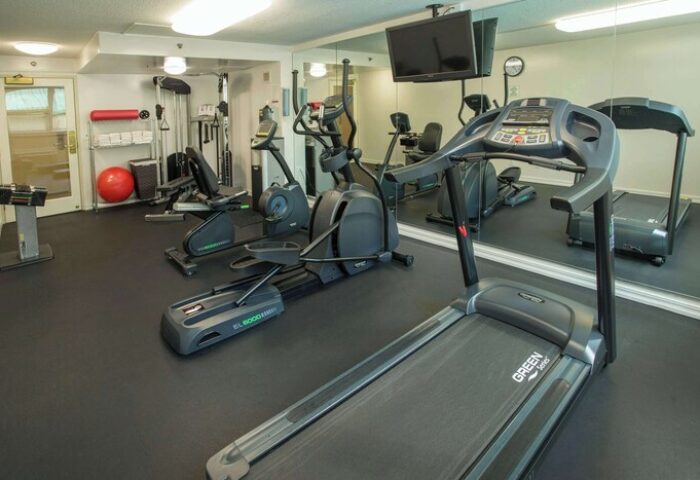 Ramada Plaza by Wyndham Waikiki gay-friendly hotel gym. Treadmill, elliptical, stationary bike, weights, and TV for a workout.
