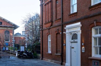 The Z Hotel Covent Garden, a gay-friendly hotel. Red brick building with white door and Z logo. Scooters parked outside. London gay travel.