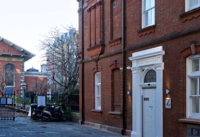 The Z Hotel Covent Garden, a gay-friendly hotel. Red brick building with white door and Z logo. Scooters parked outside. London gay travel.