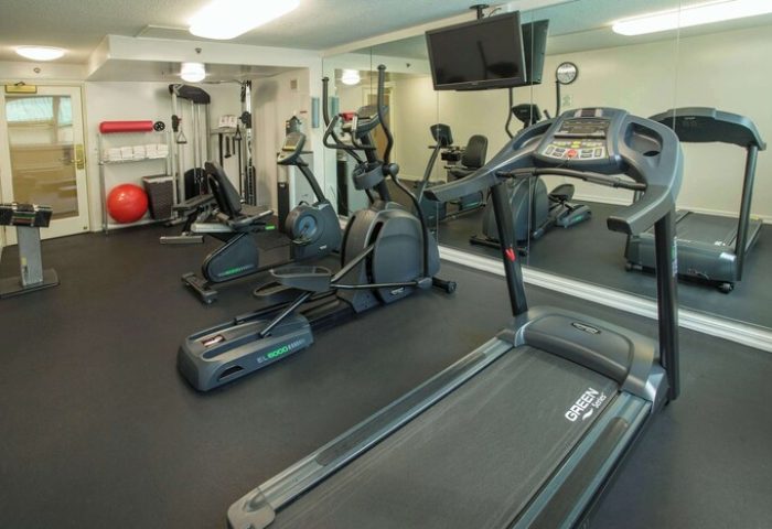 Ramada Plaza by Wyndham Waikiki gay-friendly hotel gym. Treadmill, elliptical, stationary bike, weights, and TV for a workout.