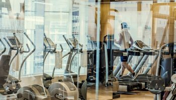 Four Seasons Hotel and Residences Fort Lauderdale gym. Man on treadmill at this gay-friendly hotel. Fitness center with exercise equipment.