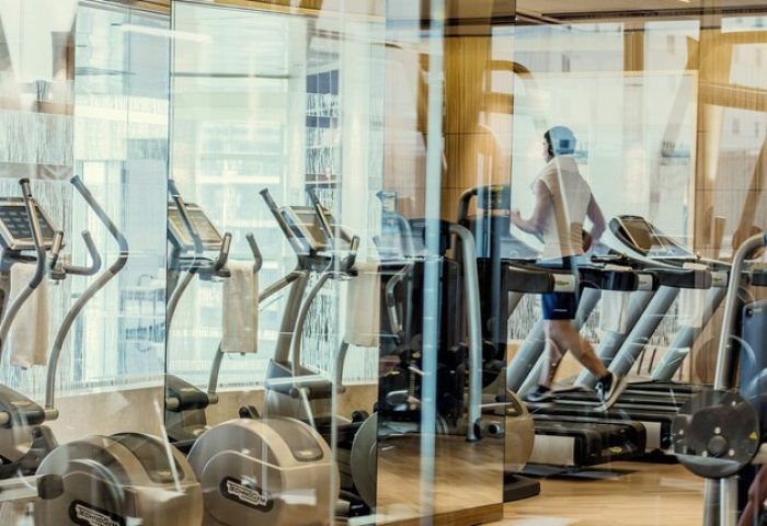 Four Seasons Hotel and Residences Fort Lauderdale gym. Man on treadmill at this gay-friendly hotel. Fitness center with exercise equipment.