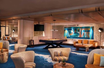 The Ritz-Carlton, Fort Lauderdale gay-friendly hotel: Lounge area with pool table, seating, and colorful artwork. Upscale gay travel experience.