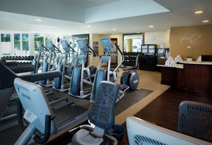 Hilton Fort Lauderdale Beach Resort gym. Gay-friendly hotel fitness center with treadmills, elliptical machines, weights, and spa reception desk.