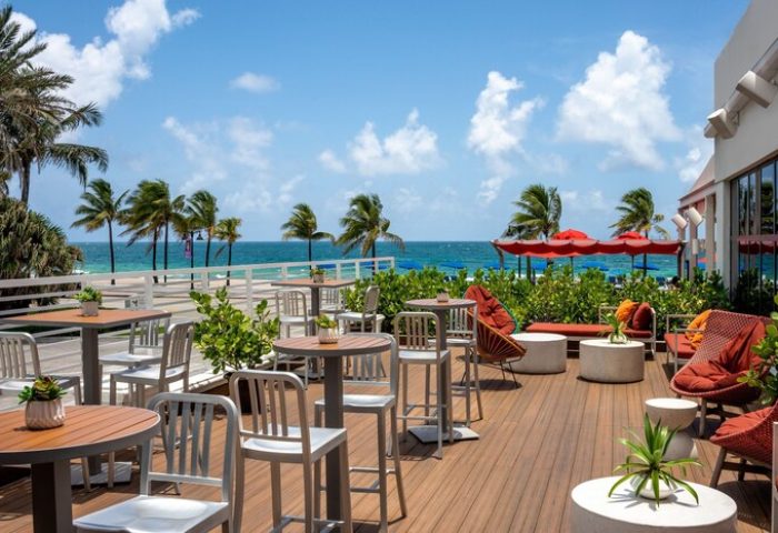 The Westin Fort Lauderdale Beach Resort's gay-friendly outdoor dining area. Tables, chairs, ocean view, and palm trees. Perfect for gay travel.