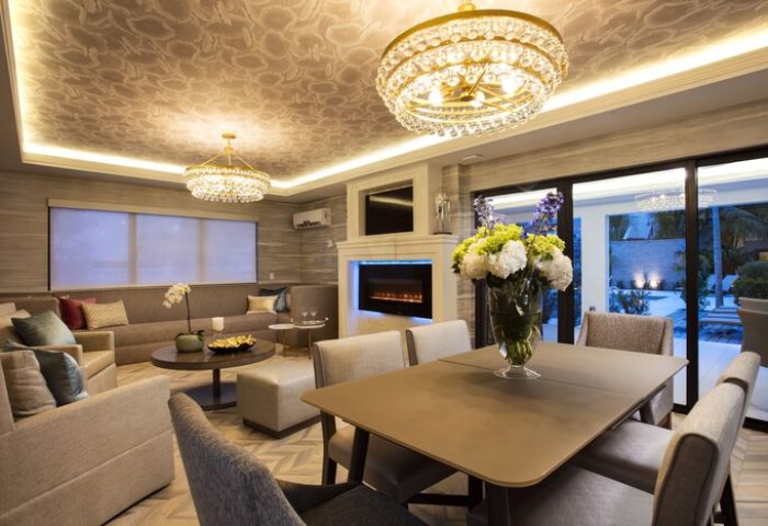 Elita Hotel gay-friendly interior. Modern living room with sofas, fireplace, and dining table. Crystal chandeliers add elegance to this space.