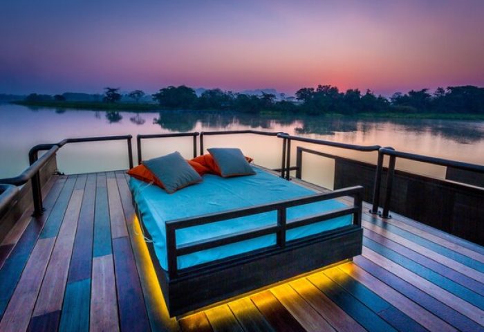 Cross River Kwai gay-friendly hotel. Outdoor bed on a deck at sunset, overlooking the river. A perfect spot for relaxation and romance.