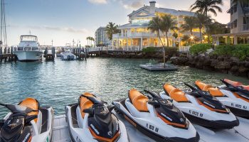 Hyatt Centric Key West Resort: Jet skis at the gay-friendly hotel's marina. Boats docked, palm trees, & resort building in the background.
