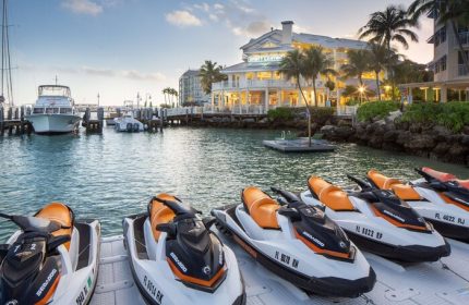 Hyatt Centric Key West Resort: Jet skis at the gay-friendly hotel's marina. Boats docked, palm trees, & resort building in the background.