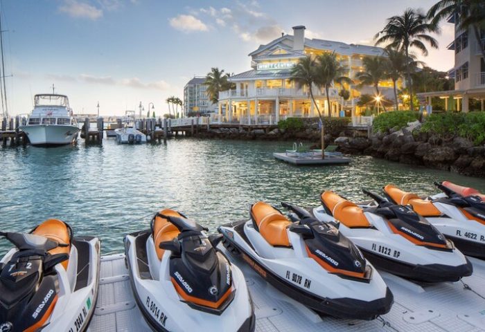 Hyatt Centric Key West Resort: Jet skis at the gay-friendly hotel's marina. Boats docked, palm trees, & resort building in the background.