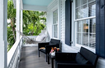Alexander's Guesthouse: Gay-friendly hotel porch with hammock, chairs, drinks. Relaxing Key West travel for gay men.