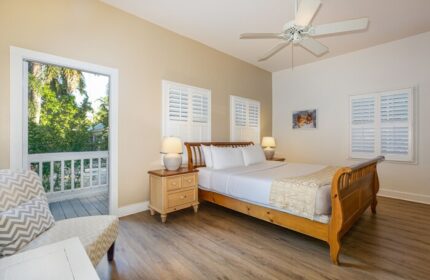 Paradise Inn adults-only gay-friendly hotel bedroom. Queen bed, ceiling fan, and balcony. A relaxing room for gay men's travel.