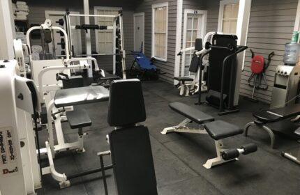 Gym at a gay-friendly hotel in New Orleans. Fitness equipment includes weight machines, benches, & water cooler. A great amenity for gay travelers.