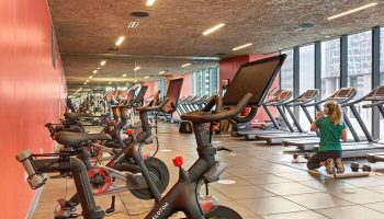 EAST Miami Gay-Friendly Hotel gym. Peloton bikes and treadmills offer a workout with a view. Modern fitness center for hotel guests.