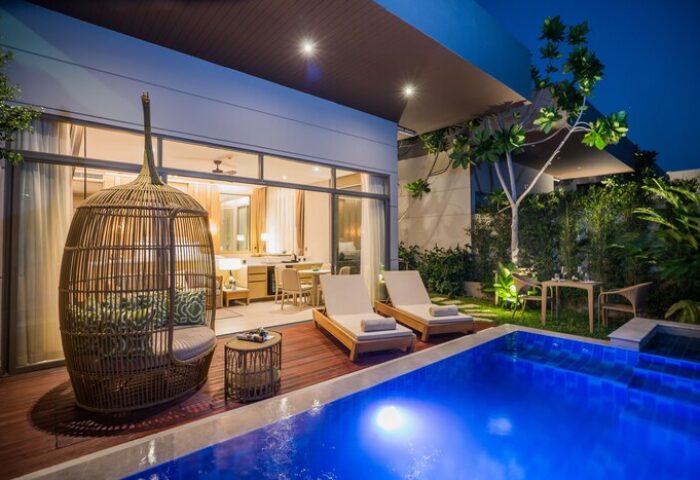 Avani+ Hua Hin Resort villa with pool at dusk. Gay-friendly hotel with outdoor lounge chair, sunbeds, and dining area. Perfect for gay travel.