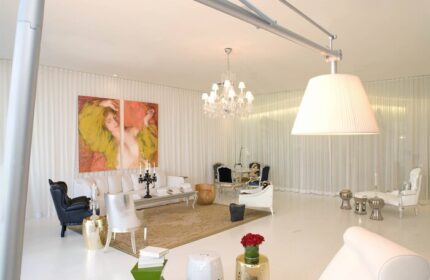 W Miami gay-friendly hotel suite. Chic living space with modern furniture, chandelier, and artwork. Luxury travel for gay men in Miami.