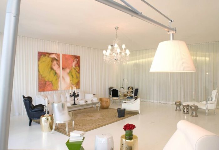W Miami gay-friendly hotel suite. Chic living space with modern furniture, chandelier, and artwork. Luxury travel for gay men in Miami.