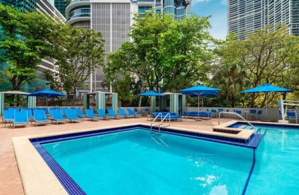 Hyatt Regency Miami gay-friendly hotel pool. Hotel with blue lounge chairs, umbrellas, and cabanas. Great for gay travel to Miami.