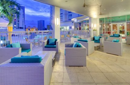 Hampton Inn & Suites Miami/Brickell-Downtown outdoor lounge. Gay-friendly hotel with comfy seating, pool view. Perfect for relaxing in Miami's vibrant scene.