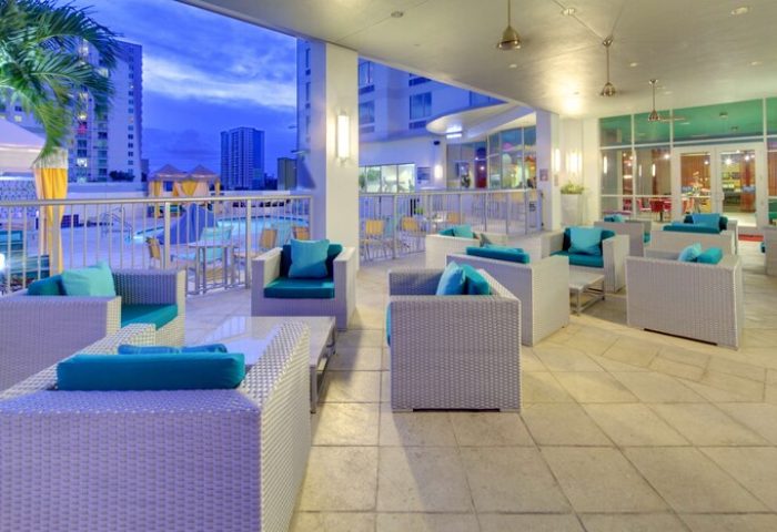 Hampton Inn & Suites Miami/Brickell-Downtown outdoor lounge. Gay-friendly hotel with comfy seating, pool view. Perfect for relaxing in Miami's vibrant scene.