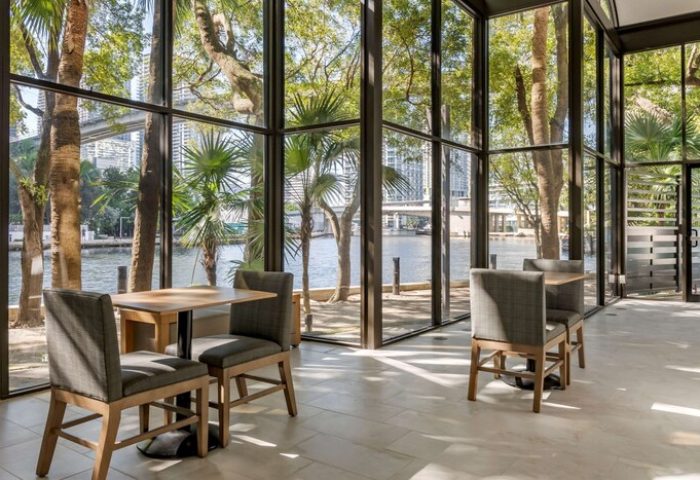 Comfort Inn Downtown Brickell-Port of Miami gay-friendly hotel view. Tables and chairs overlook the river and city. Modern design.