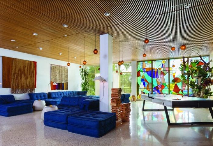 The Standard Miami gay-friendly hotel lobby. Blue sofas, tapestries, and a stained-glass window create a stylish, welcoming atmosphere.