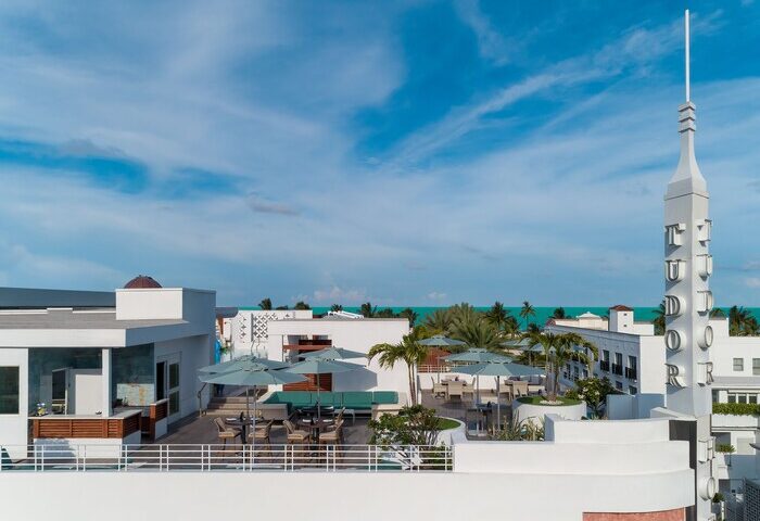 Dream South Beach, a gay-friendly hotel, part of Hyatt. Rooftop view of the Tudor building, palm trees, and ocean. A perfect vacation spot.