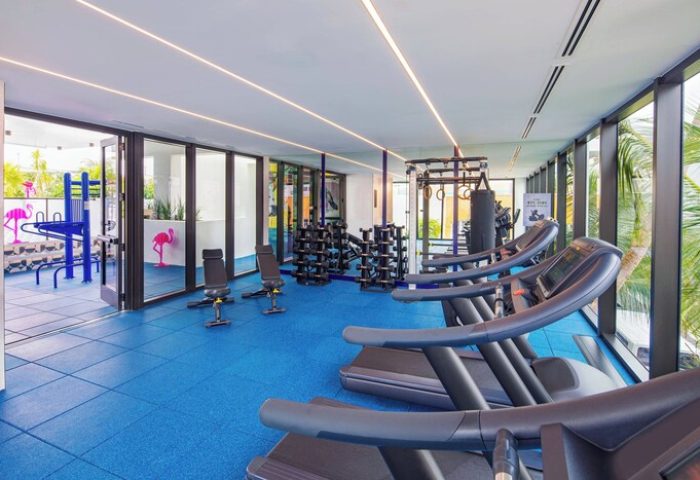 Moxy Miami South Beach gay-friendly hotel gym. Treadmills, weights, & flamingo decor. A fun & inclusive workout space in Miami's South Beach.